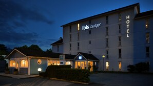 Ein Hotel mit einem Schild, auf dem "ibis budget hotel" steht, und einem kleineren Schild mit der Aufschrift "ibis budget".