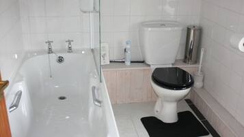 A bathroom with a bathtub, toilet, and a sink.
