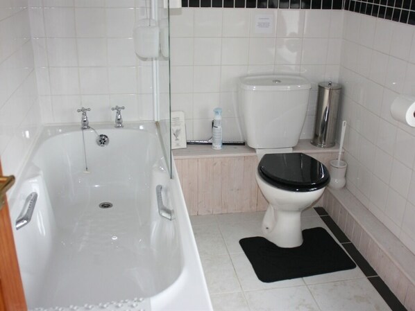 A bathroom with a bathtub, toilet, and a sink. - The Old School House (Llanbrynmair)