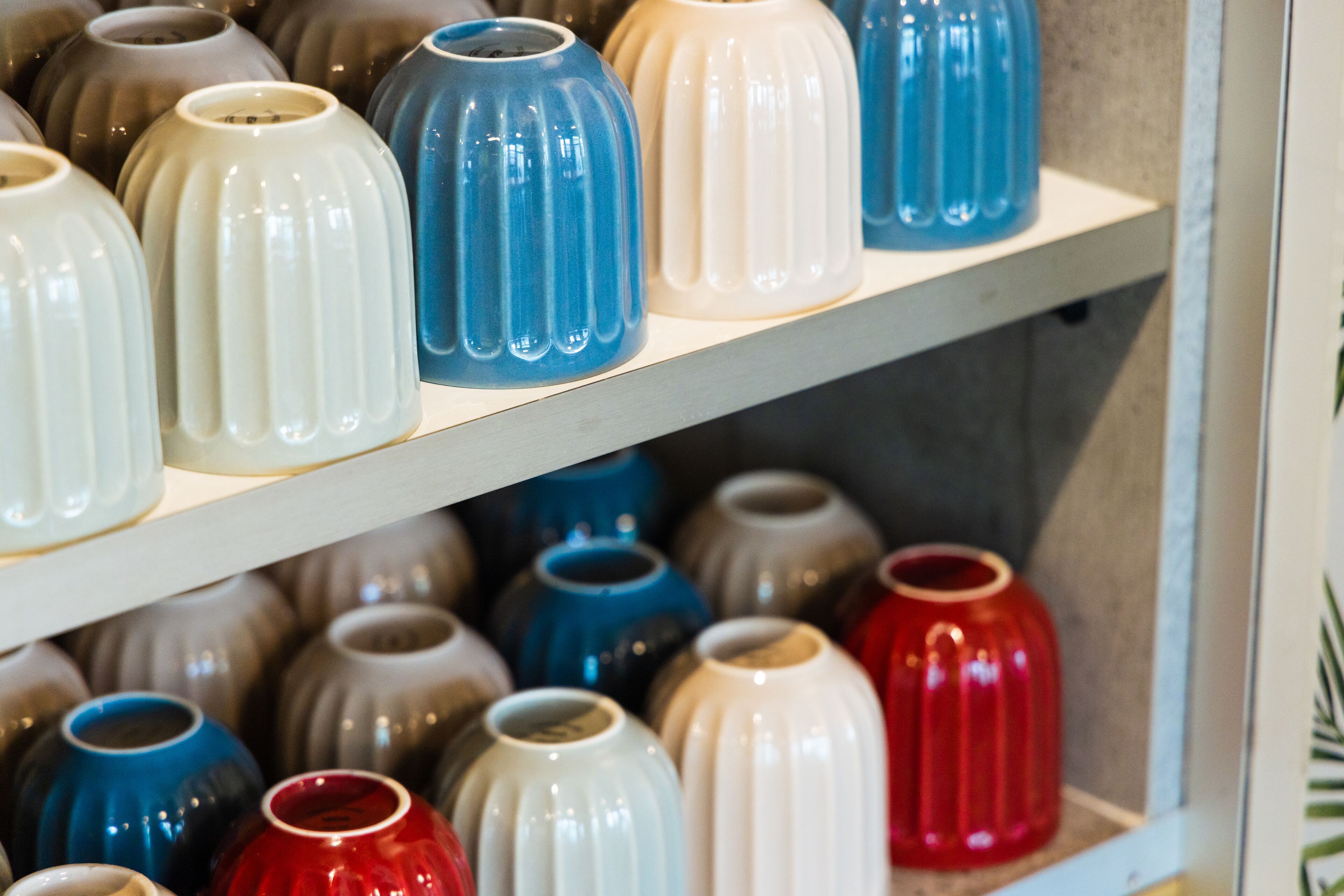 A shelf with various ceramic vases in different shapes and sizes.