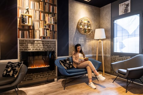 A cozy reading area with a fireplace, bookshelves, and comfortable seating.