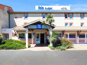 A two-story hotel with a sign reading 'ibis budget hotels.'