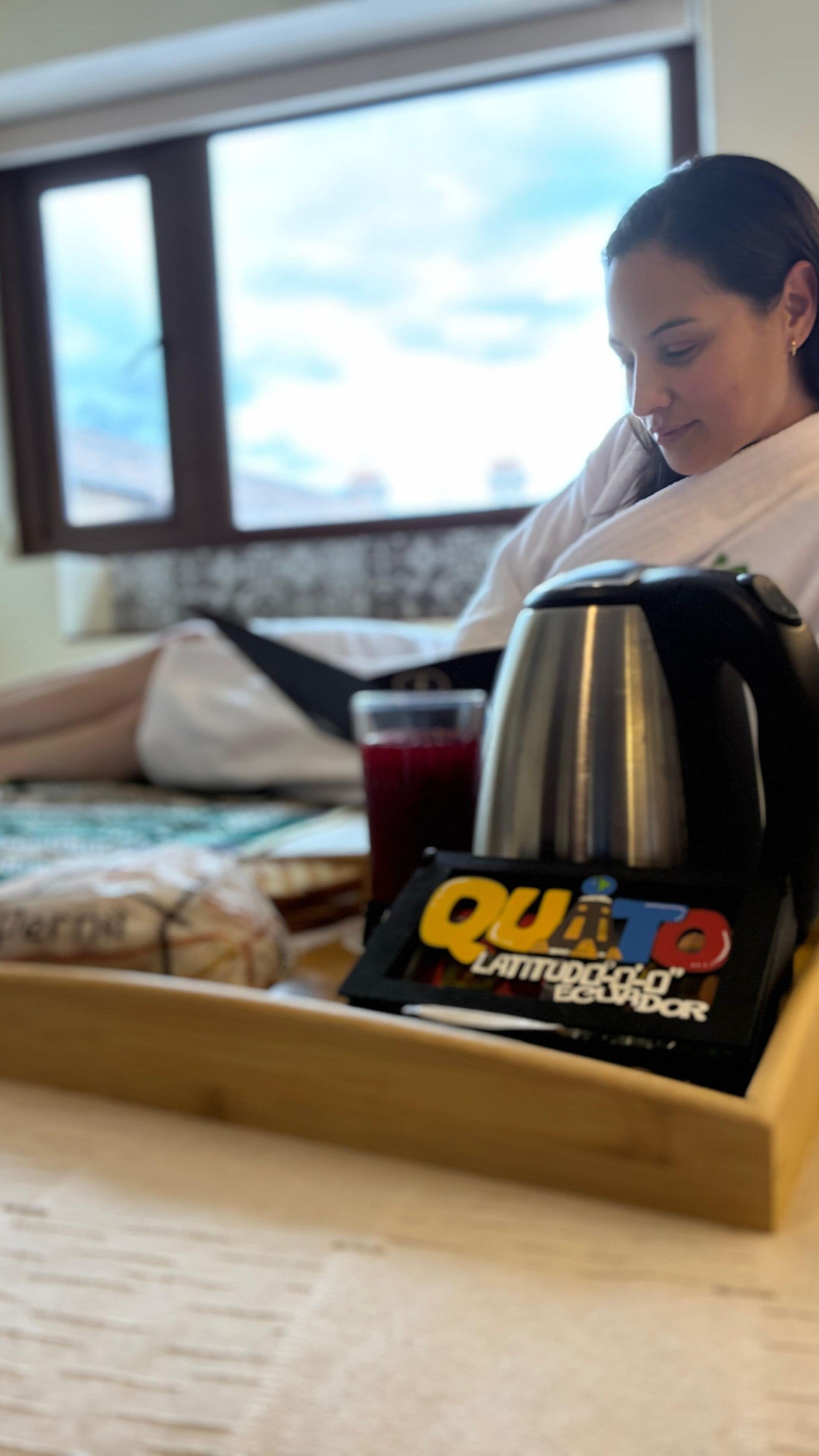 A tray with a coffee pot, a glass of red drink, and a box labeled "Quinto Latitud 5° Ecuador."