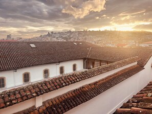 A view of terracotta-tiled rooftops and white walls, likely part of a historic building.