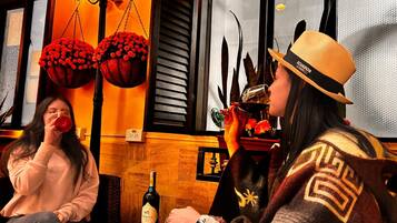 Dos personas sentadas en una mesa con una botella de vino y un plato de fruta.