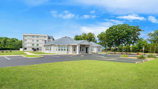 A modern building with a parking lot and green lawns. - Sonesta Essential Atlantic City West (Egg Harbor Township)