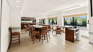 A spacious dining area with high ceilings, recessed lighting, and large windows offering views of the outdoors. - Sonesta Essential Atlantic City West (Egg Harbor Township)