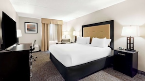 A hotel room with a large bed, bedside tables with lamps, a desk with a chair, a TV, and a framed picture on the wall. - Sonesta Essential Atlantic City West (Egg Harbor Township)