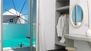 A modern bathroom with a bathtub, a vanity, and a mirror. - Drops villas (Santorini)