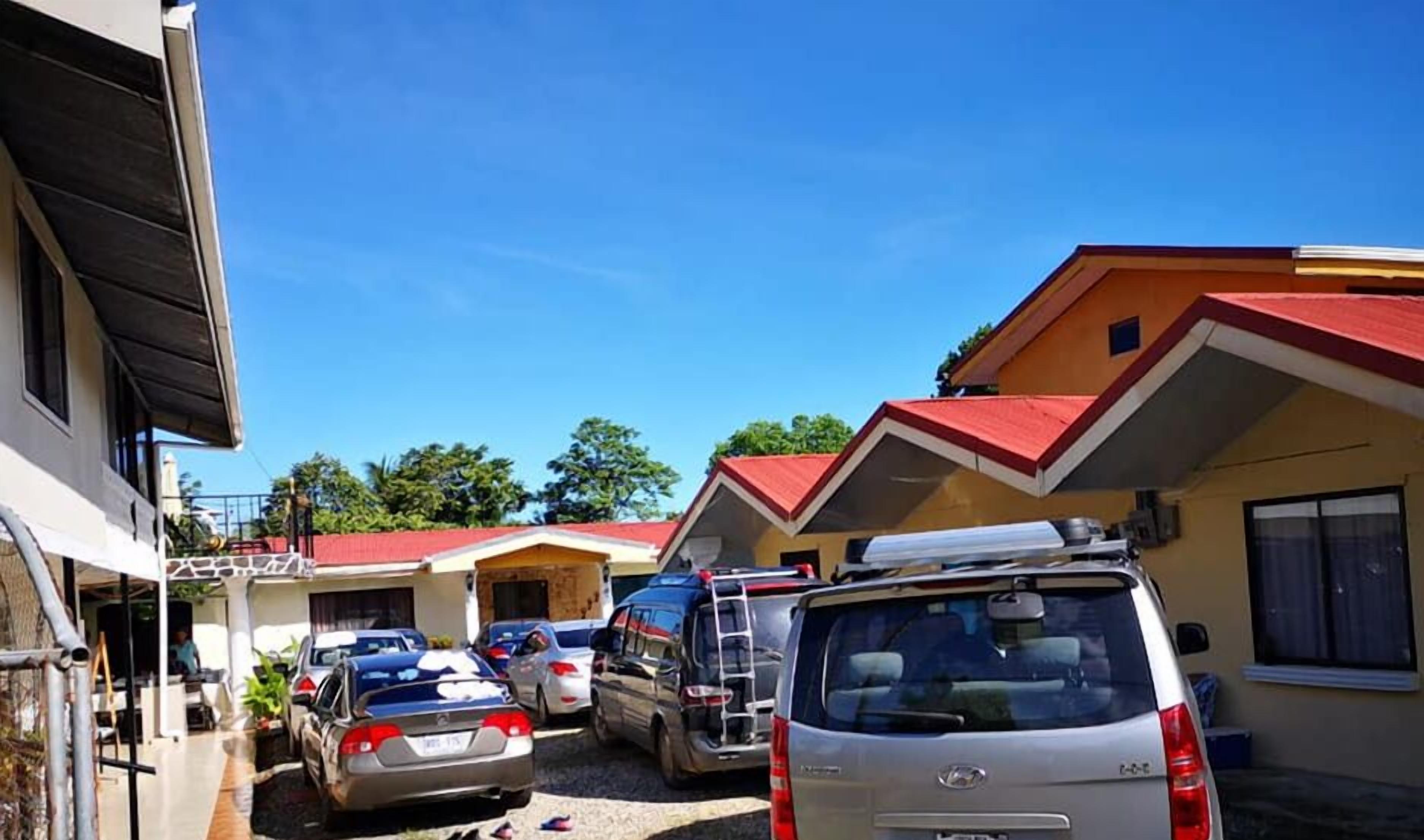 A parking area with several cars, including a silver van and a black SUV.
