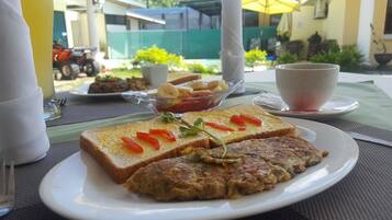 A breakfast setting with toast, a fried egg, and a side of fruit on a plate.