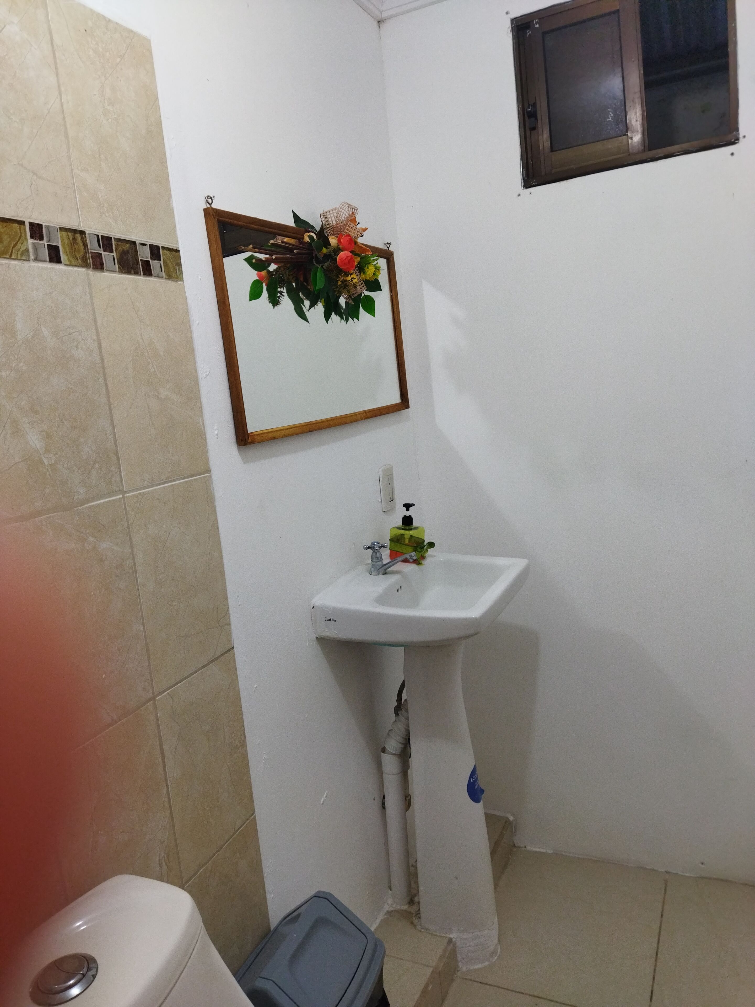 A bathroom with a white sink, a mirror, and a toilet.