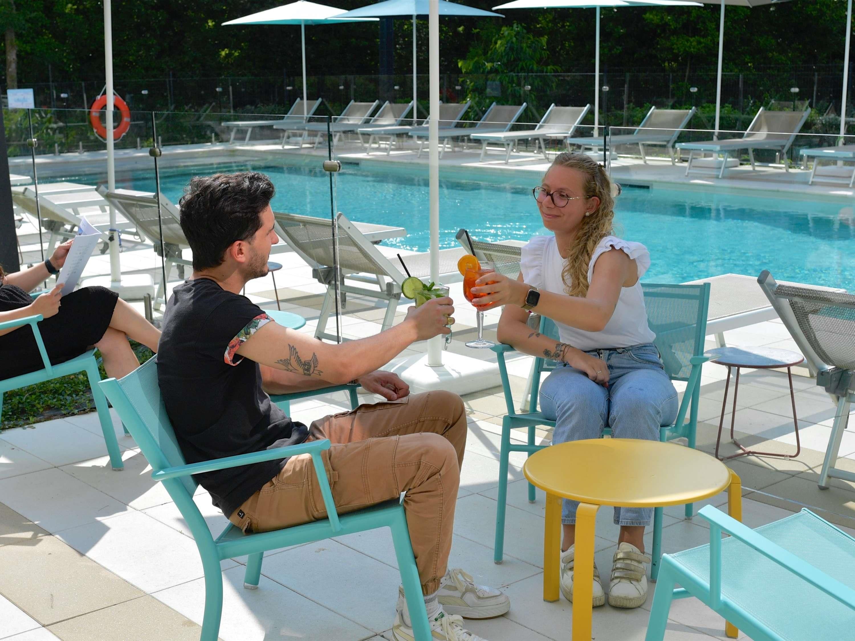 A poolside area with lounge chairs, a small round table, and a lifebuoy.