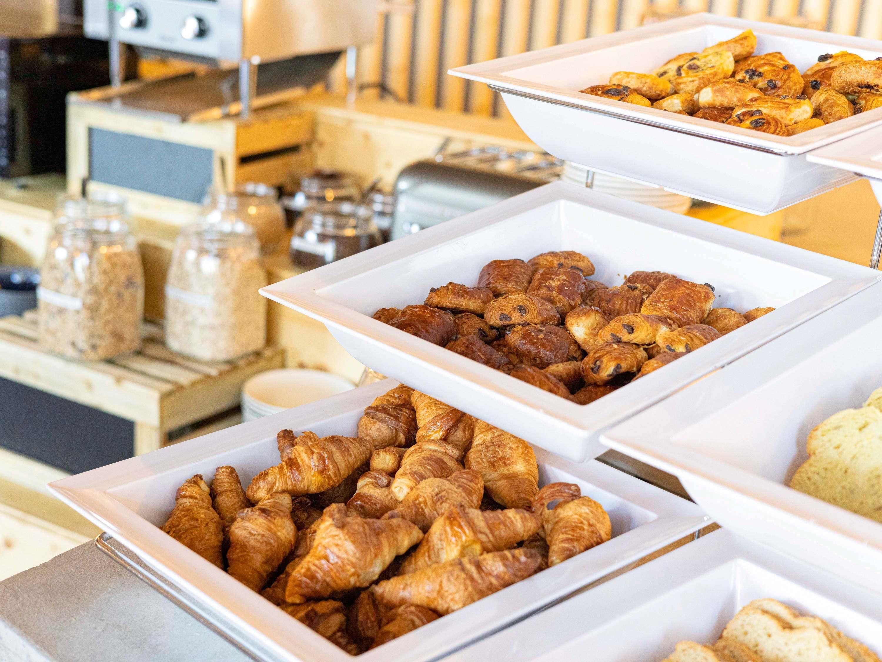 Un buffet proposant une variété de produits de boulangerie, notamment des croissants et des pâtisseries.