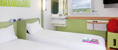 Habitación de hotel con dos camas, baño, televisor y ventana con vistas.