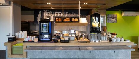 Montaje de bufé con diferentes opciones de comida y una estación de café.