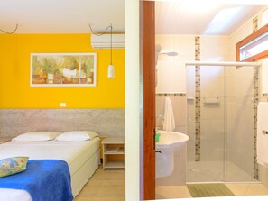 A bedroom with a bed, bedside table, and a painting on the wall.