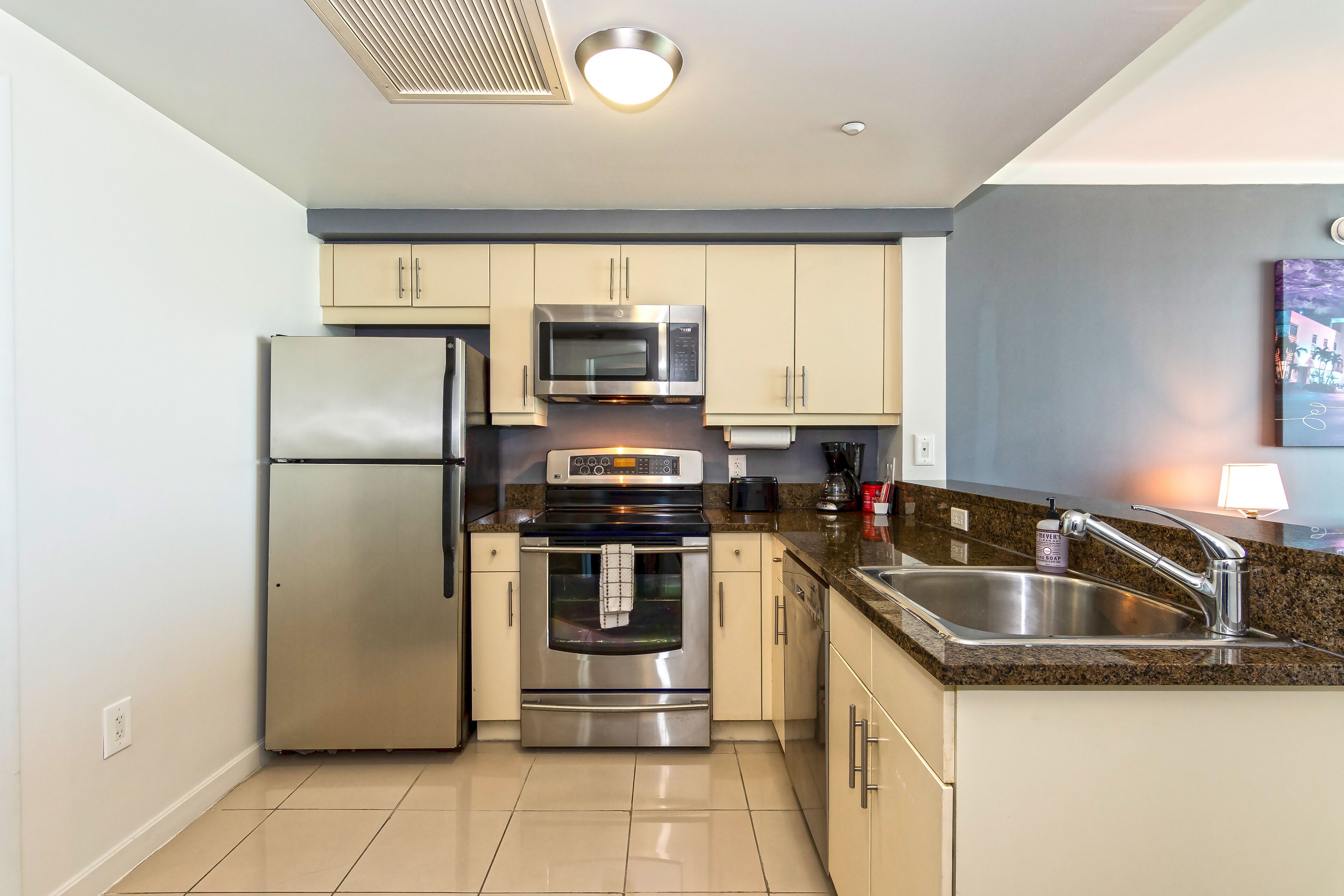A modern kitchen with stainless steel appliances, a granite countertop, and a built-in sink.