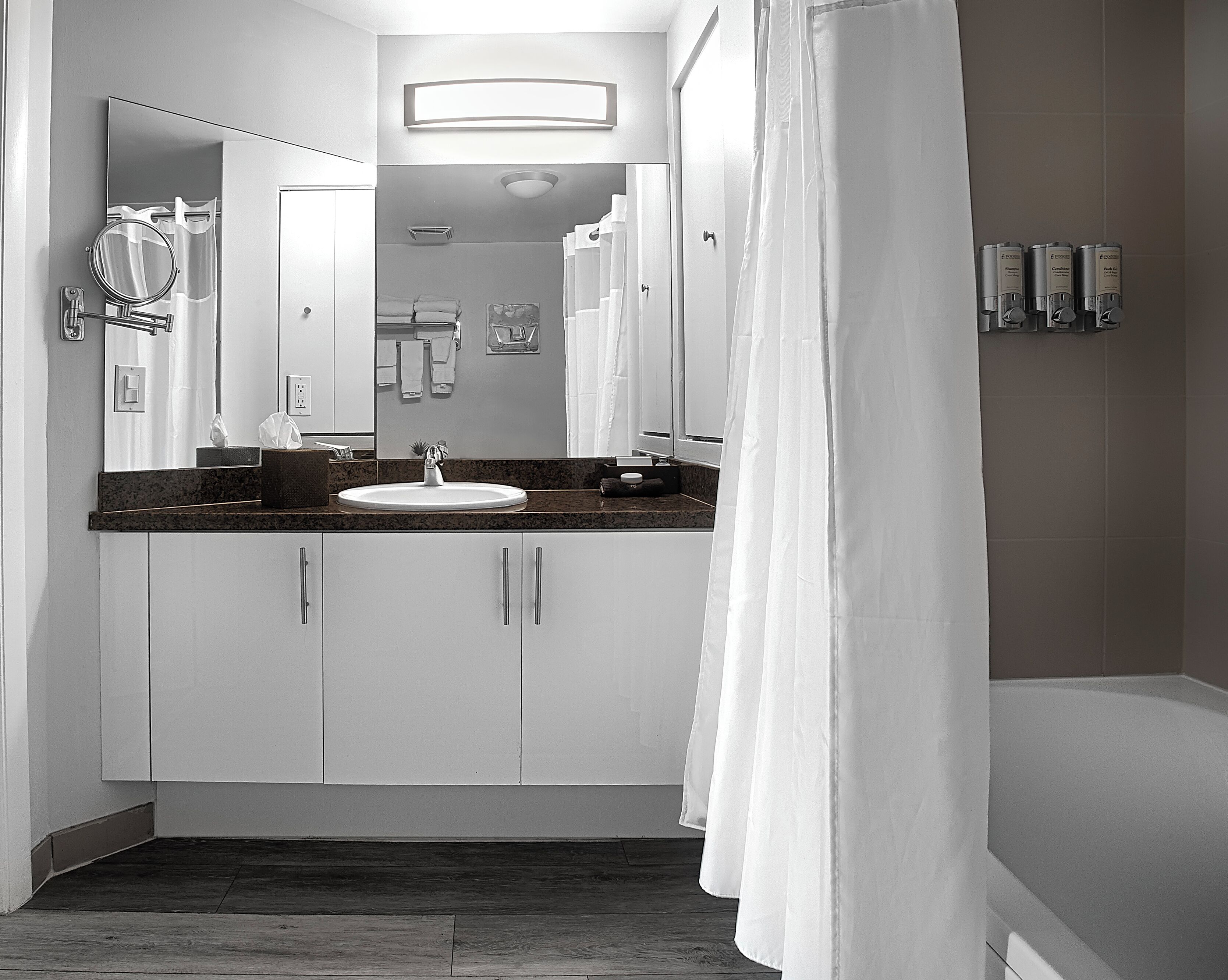 Un bagno moderno con lavandino, specchio e tenda doccia.