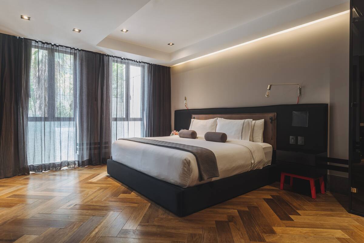 Un dormitorio moderno con una cama grande, una mesita de noche y una lámpara de escritorio.