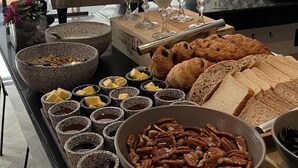 Ein reichhaltiges Frühstücksbuffet mit verschiedenen Speisen, darunter Brot, Gebäck und Obst.
