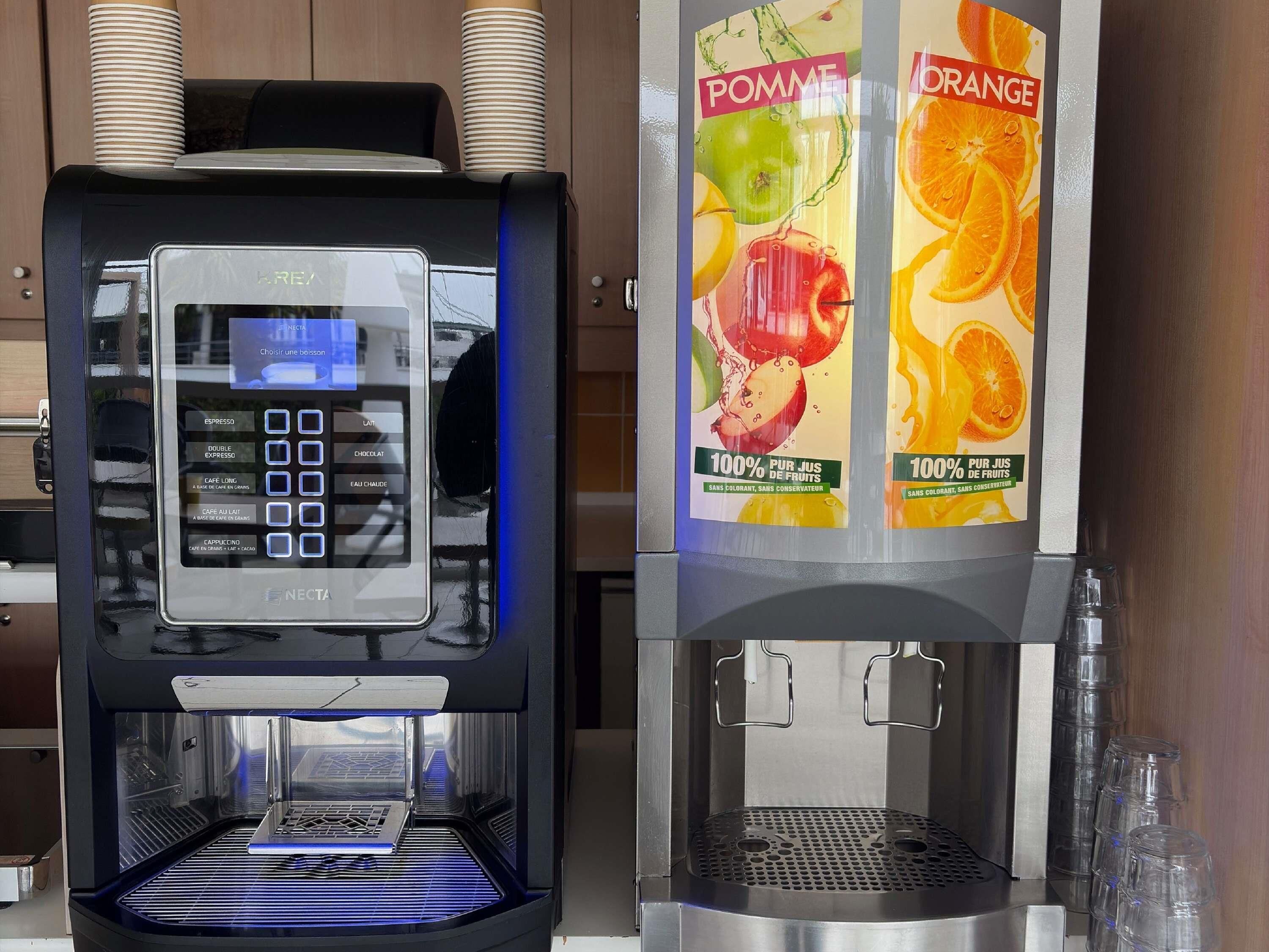 Une machine à café dotée d’un écran numérique et d’un distributeur de boissons proposant différentes saveurs de fruits.