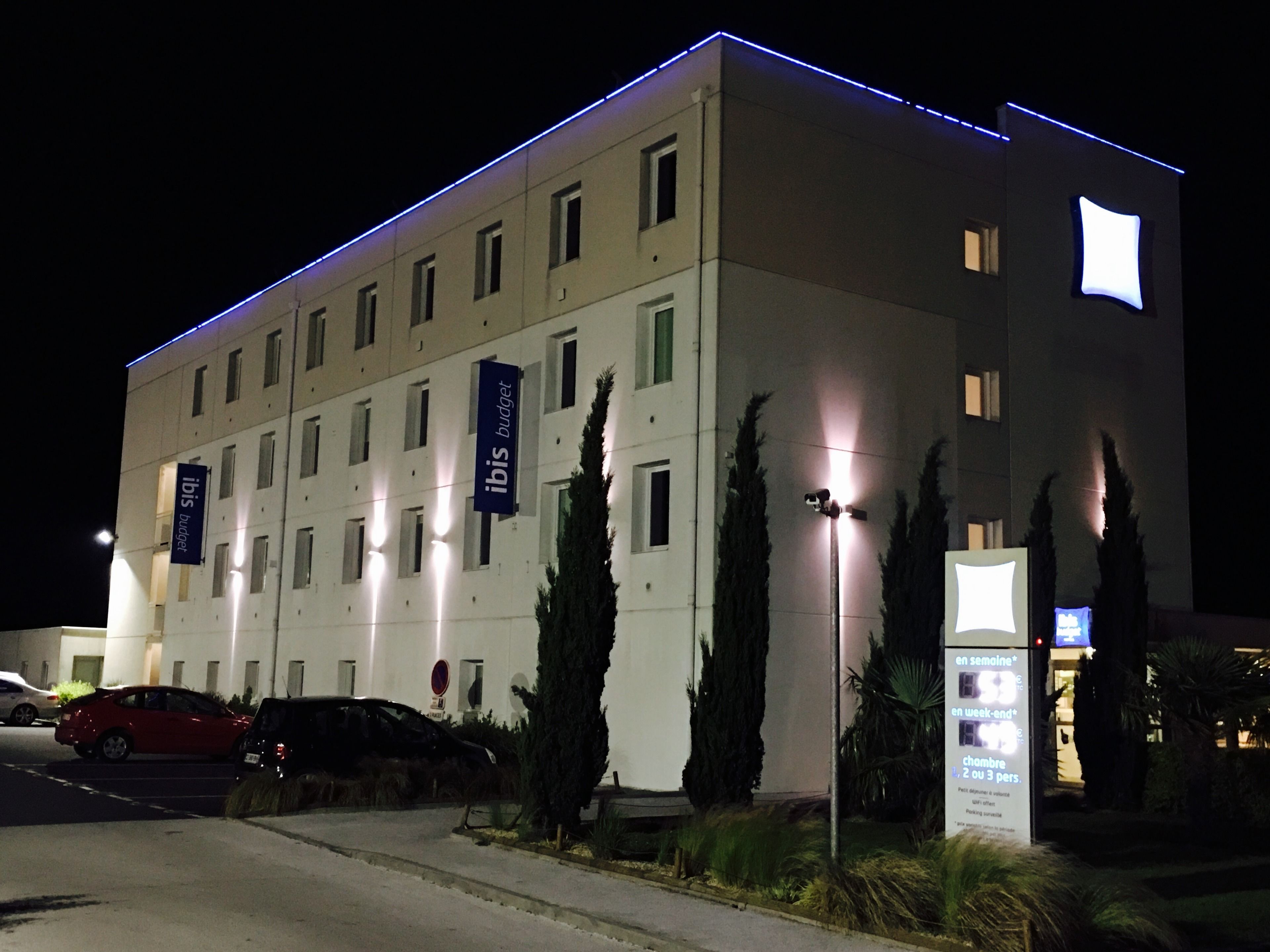 Un moderno edificio di hotel con diversi piani, illuminato da luci esterne.