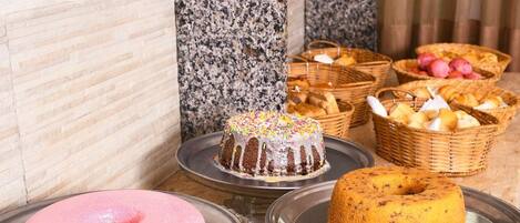 A dessert display with various cakes and pastries on trays.