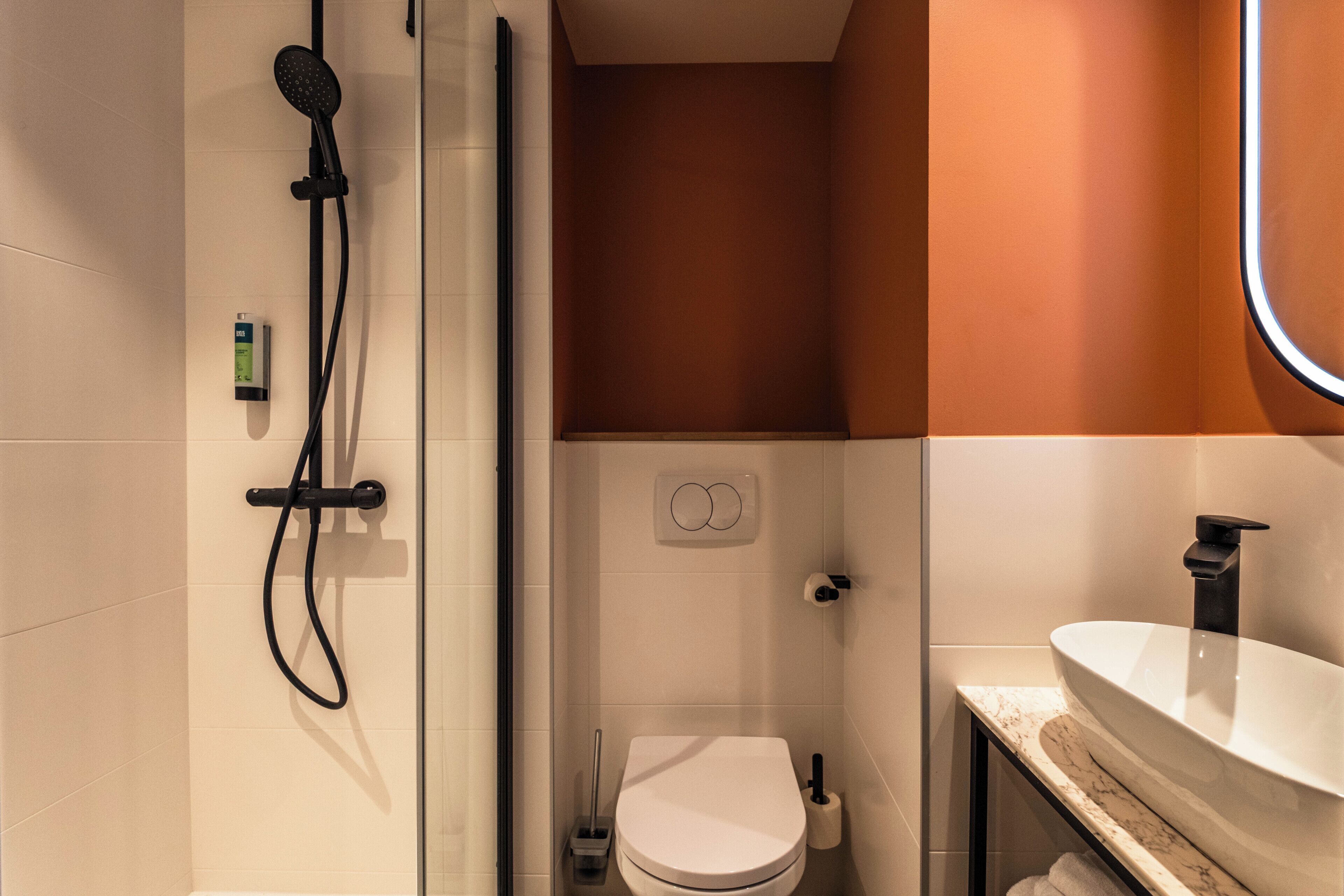 Un baño con ducha, inodoro y lavamanos.