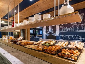 A breakfast buffet with various breads, pastries, and fruits. - ibis budget Marne la Vallee Pontault Combault (Pontault-Combault)