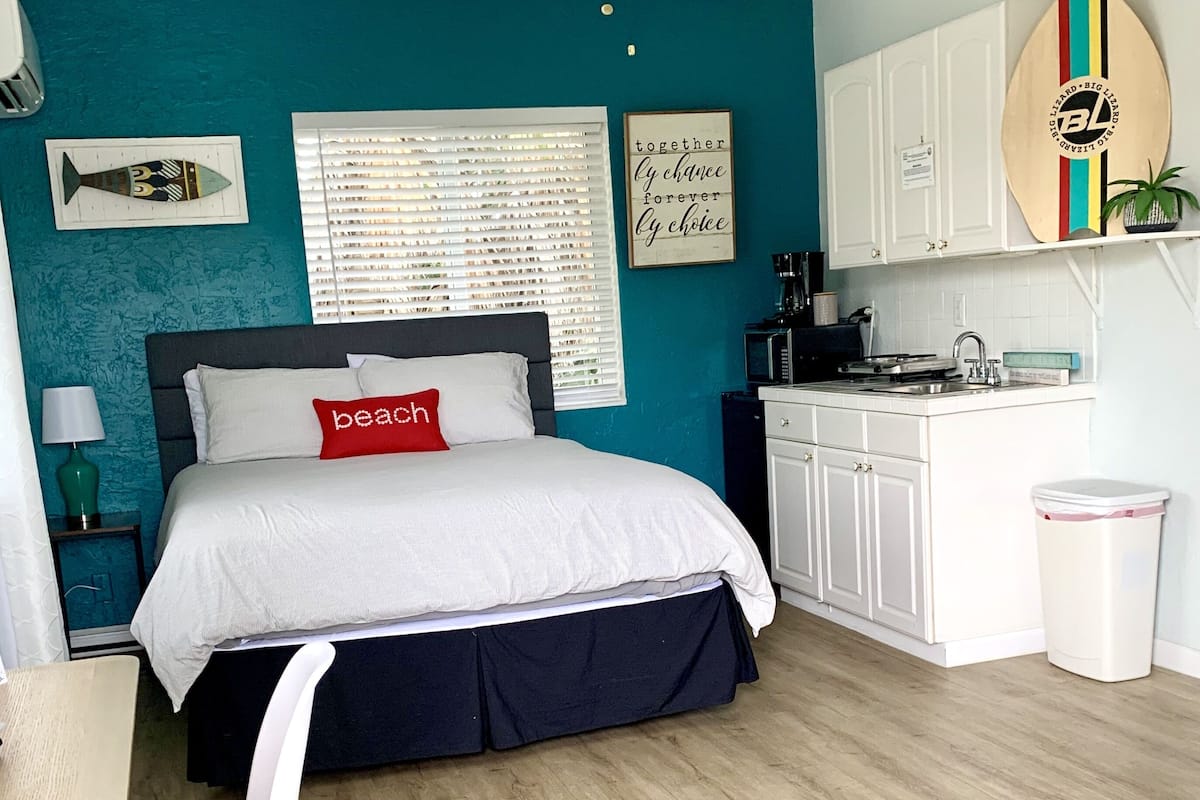 Une chambre moderne équipée d’un lit, d’un bureau et d’une kitchenette.
