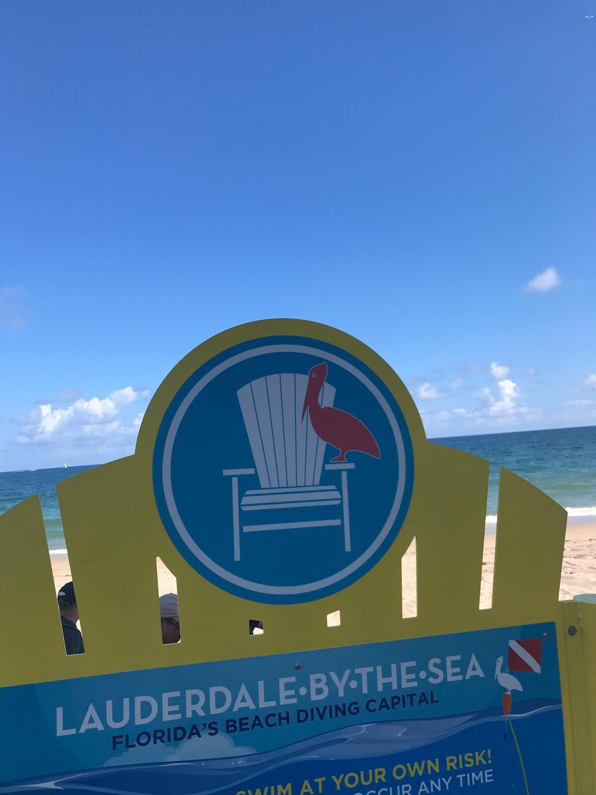 Un panneau indicateur sur la plage de Lauderdale by the Sea, considérée comme la capitale de la plongée sous-marine de Floride, avec les icônes d’un pélican et d’une chaise.