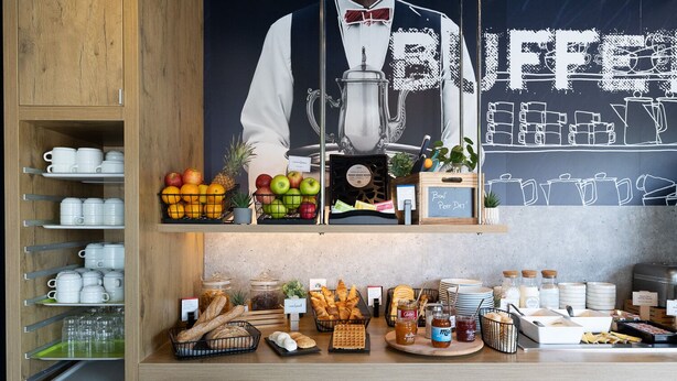 A breakfast buffet counter with various food items and a chalkboard sign that reads "BUFFET". - ibis budget Perpignan Sud (Perpignan)