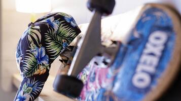 A skateboard with a colorful floral design and the word "OKELLO" on the wheel.