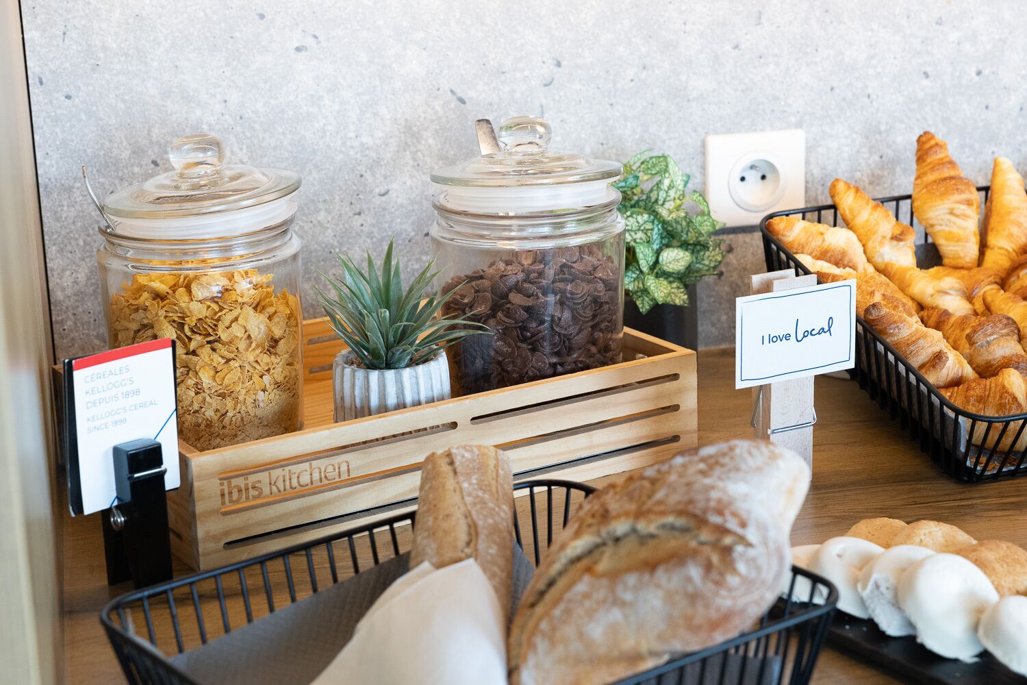 A breakfast buffet with cereal, coffee, and pastries.