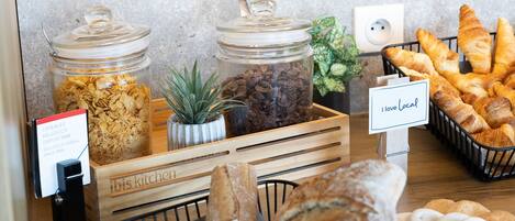 A breakfast buffet with cereal, coffee, and pastries.