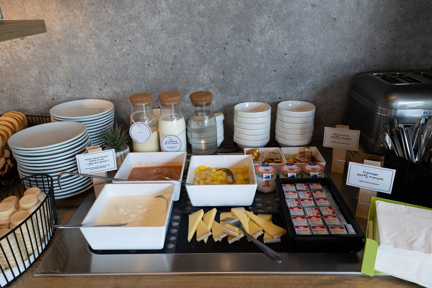A buffet with various food items including cheese, bread, and condiments.