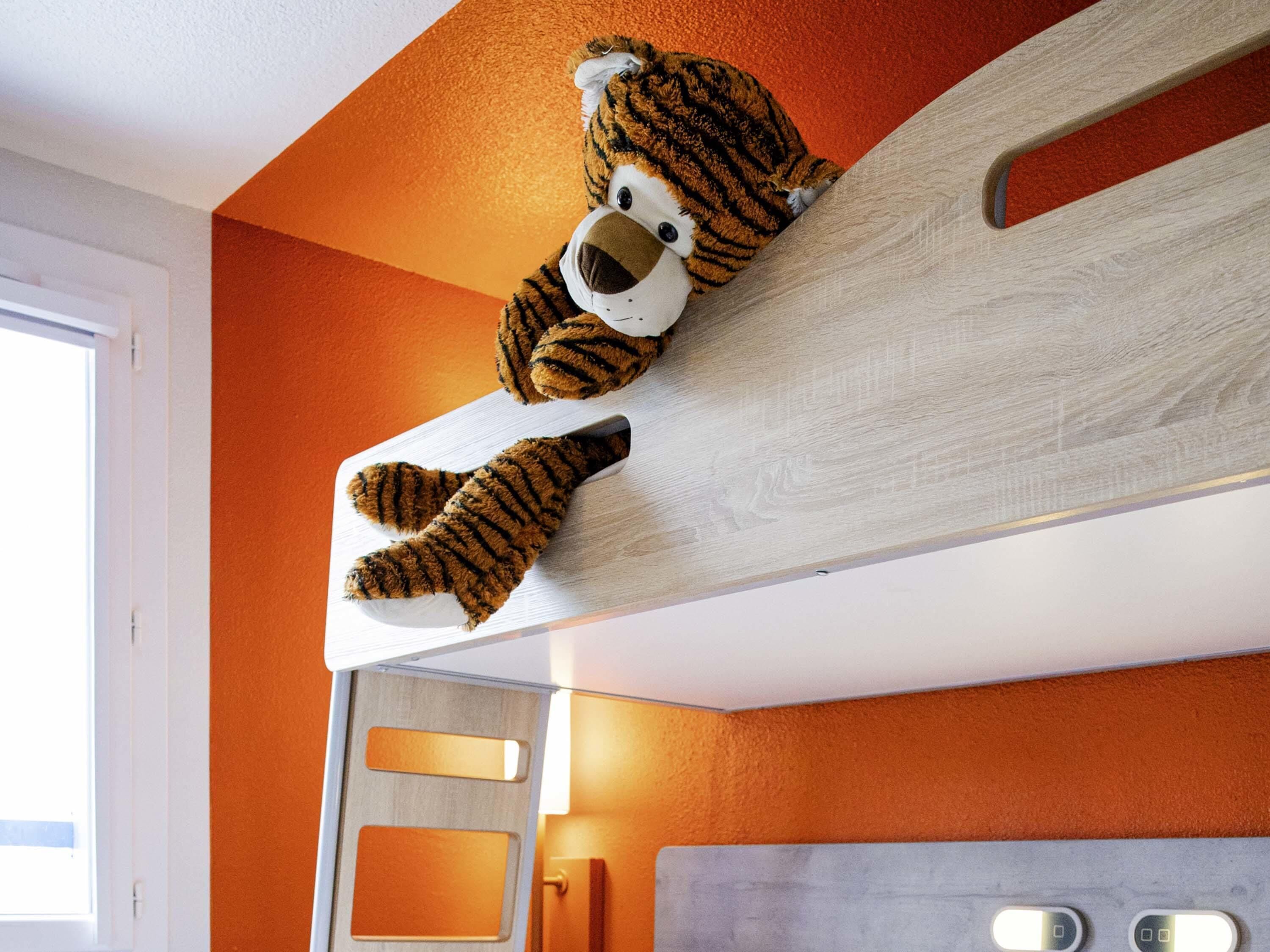 Una habitación con paredes anaranjadas, cabecera de madera y ventana.
