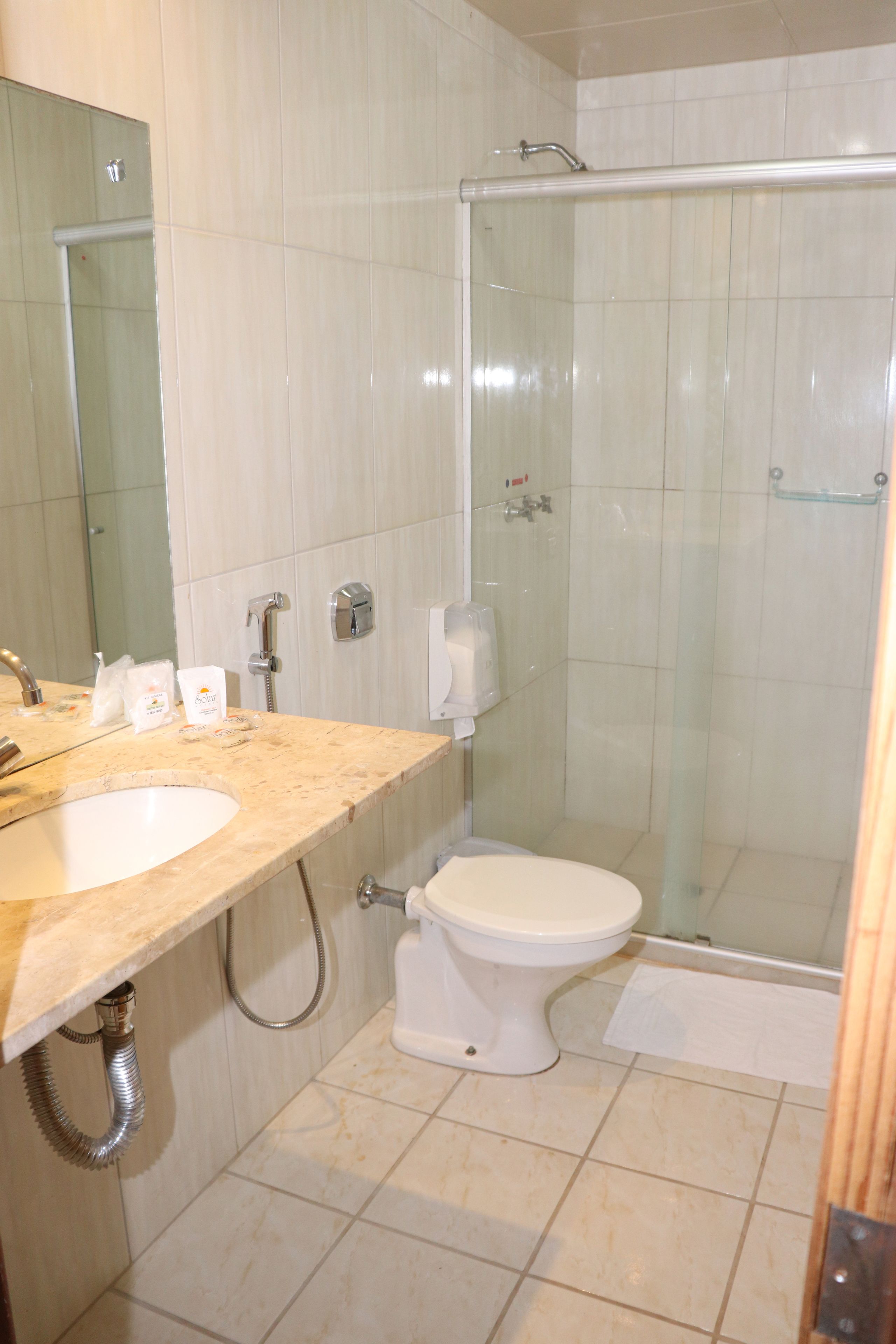 Un baño con lavamanos, inodoro y ducha.