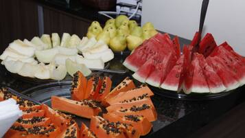 A buffet with various fruits including watermelon, papaya, and pears.