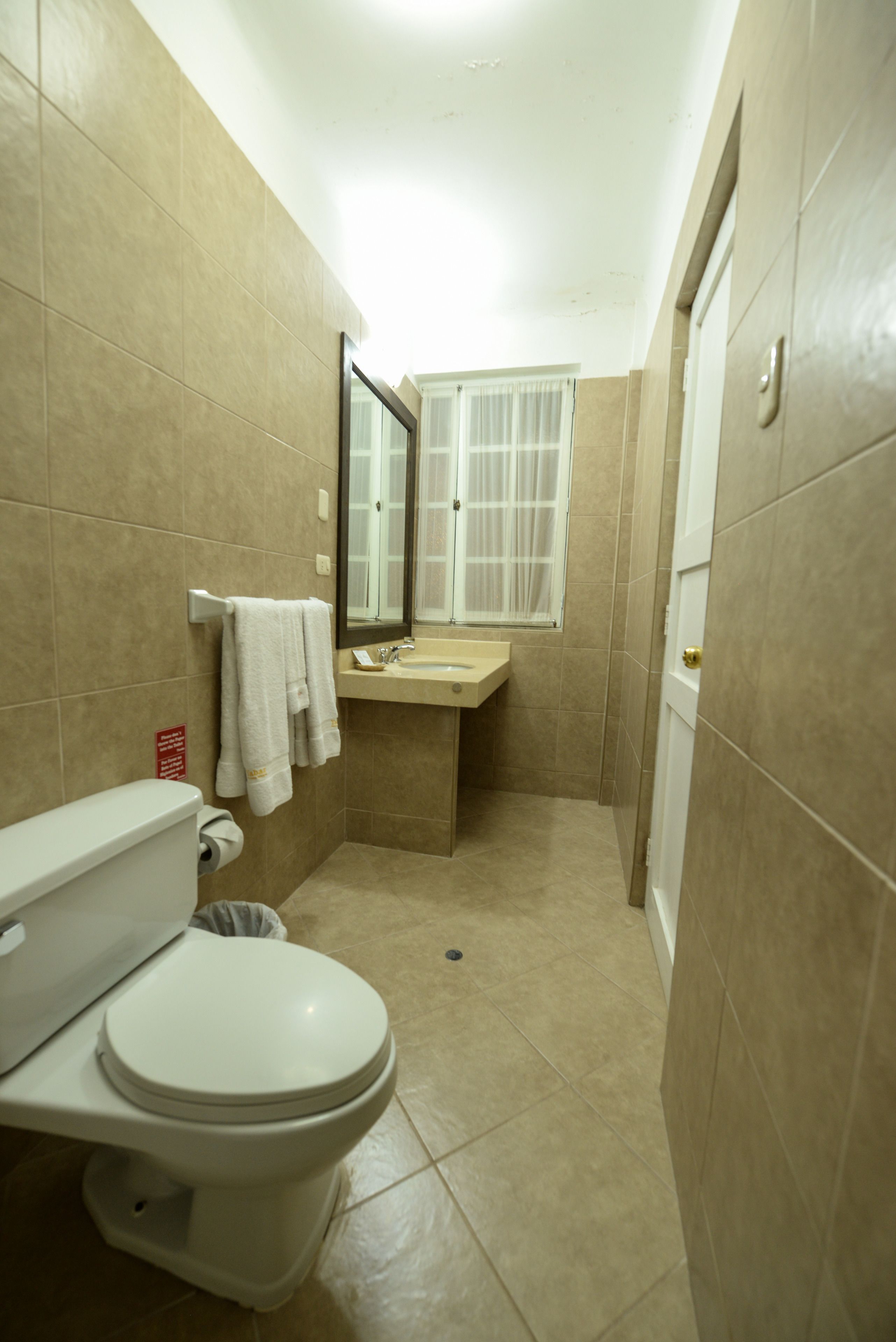 A small bathroom with a toilet, sink, and mirror.