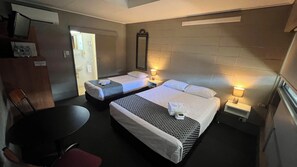 A hotel room with two beds, a desk, a chair, a mirror, and a window. - Tandara Hotel Motel (Sarina)