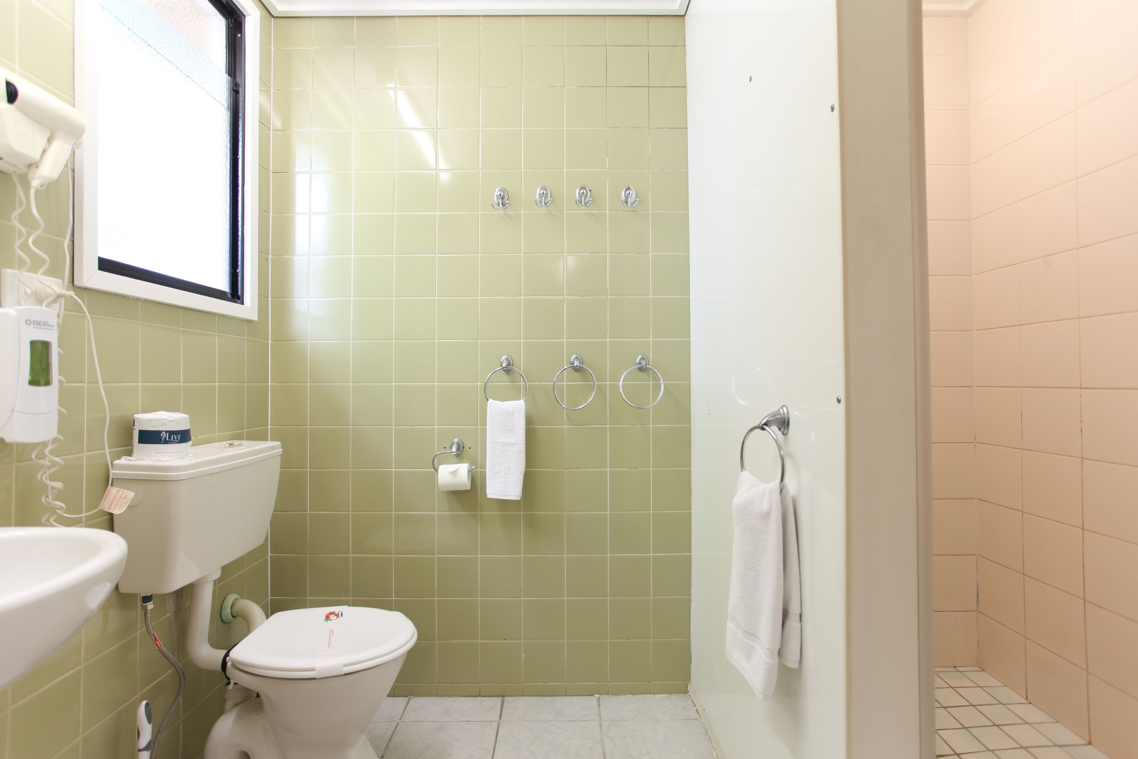 Un baño con inodoro, lavabo y zona de ducha.