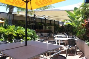 Relax in comfort under shaded tables and lush greenery.