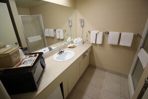 A bathroom with a sink, mirror, towel rack, and a hairdryer.
