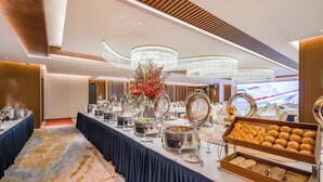 Montaje de bufé con diversos alimentos y un centro de mesa decorativo.