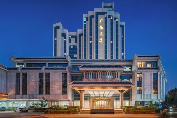 A modern hotel with a traditional architectural style, featuring a prominent entrance and multiple floors.