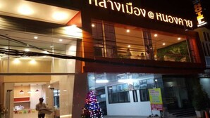 Un hotel con fachada moderna, amplias ventanas y una decoración con árbol de Navidad.
