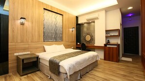Ein modernes Schlafzimmer mit einem Holzkopfteil, einem großen Wandbild, einem Nachttisch, einem Schreibtisch und einem Kleiderschrank.