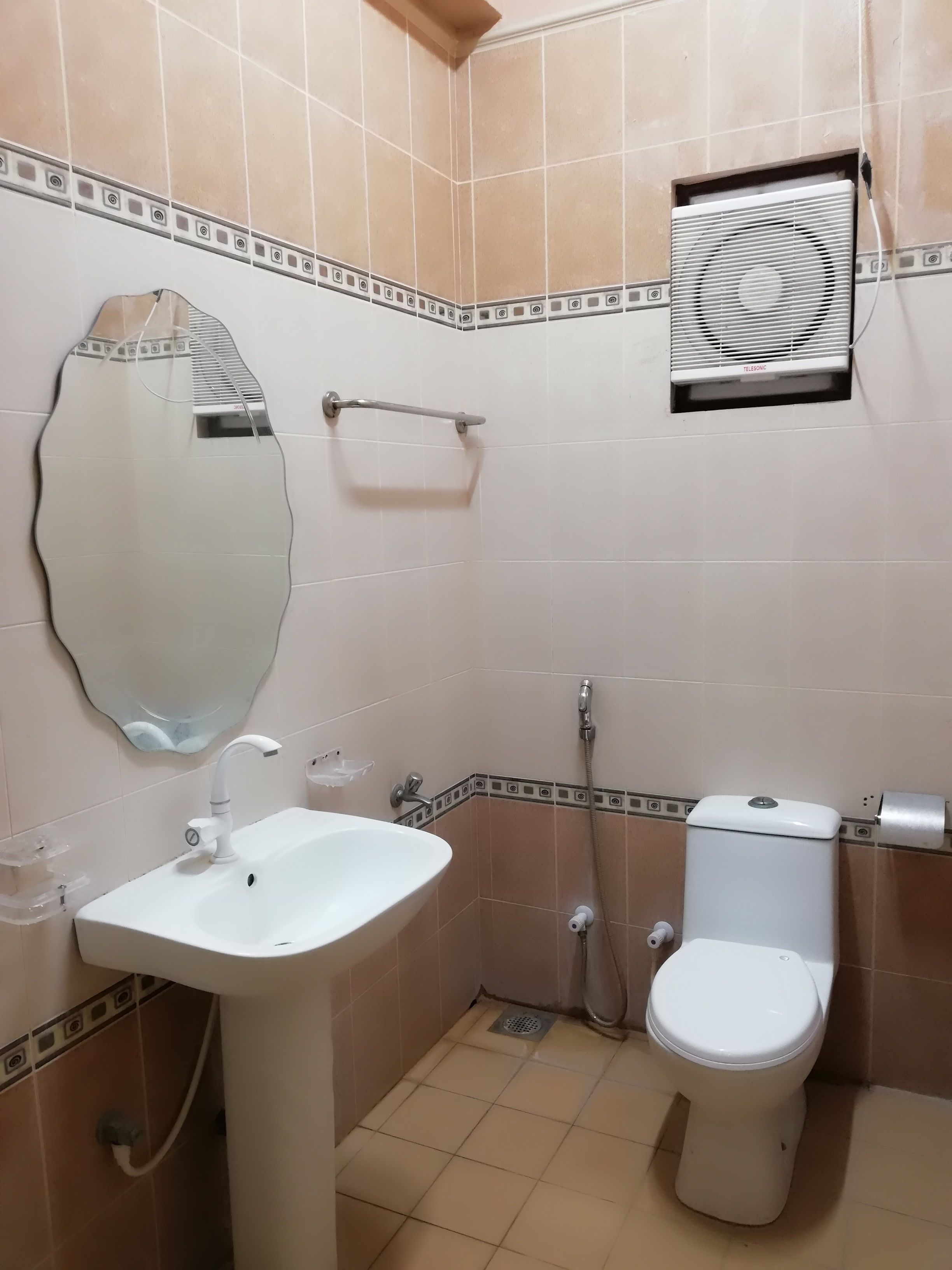Un baño con lavamanos, inodoro y espejo.